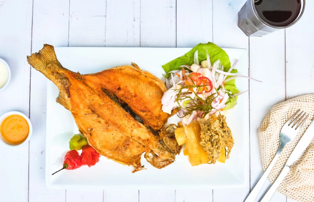 assiette de truite frite avec son yuca et sa salade d'oignon, plat typique de la gastronomie andine